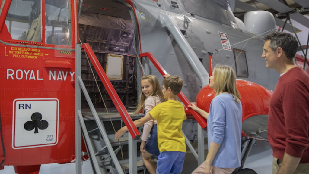 Family of four step aboard a Royal Navy display helicopter at The Fleet Air Arm Museum Yeovilton 