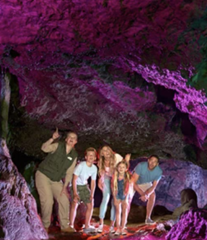 Tour guide points out features of Wookey Hole Caves to visiting family