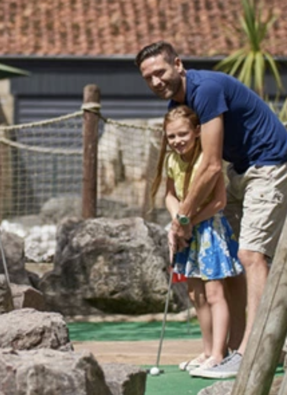 Father and daughter play crazy golf together