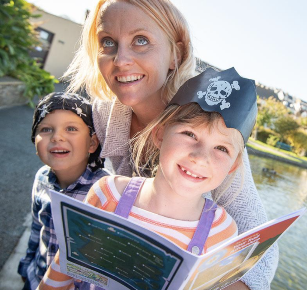 Mum and children read clues in the Glastonbury Treasure Trail Guide