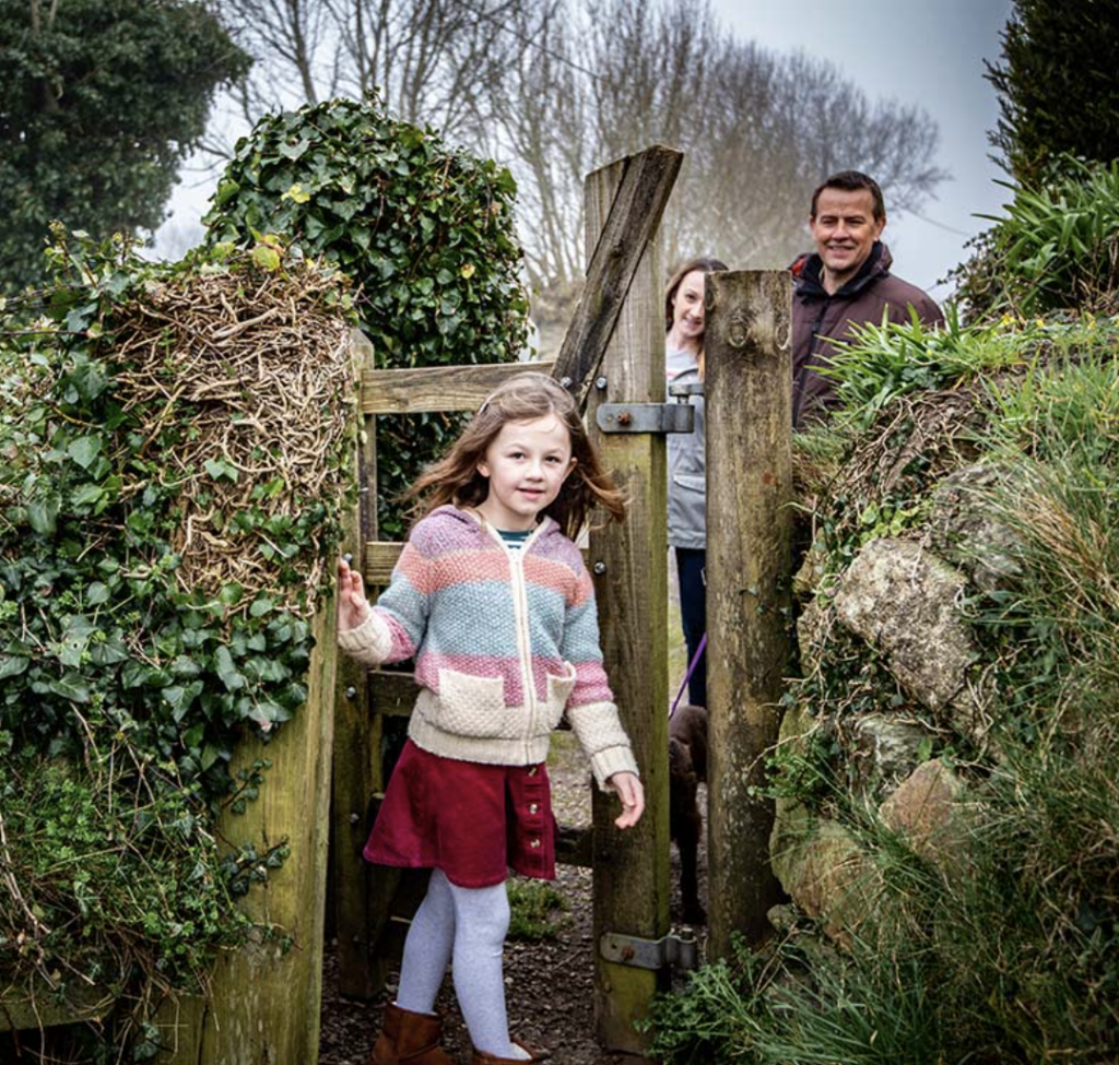 Family follows the Glastonbury Treasure Trail through a gate to the Glastonbury Tor