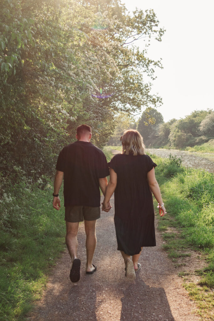 Couple walk hand in hand along the canal path