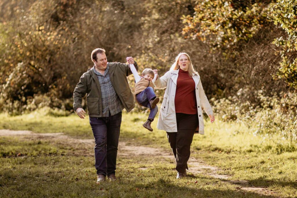 child is swung in the air between his parents