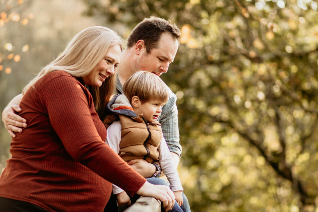 family stand together in an autumn scene