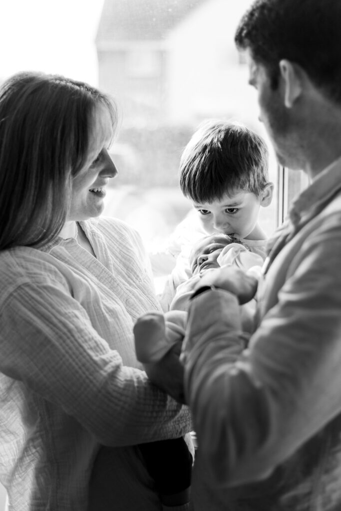 Toddler kisses younger sibling as they for a photo