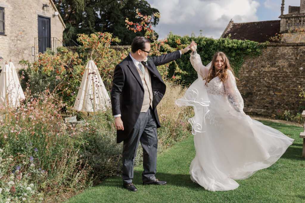 Bride and groom dance together in the garden of their reception in Somerset